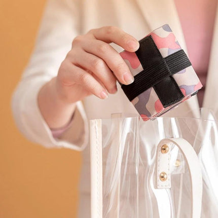 Foldable Travel Shopping Bag For Everyday Errands Navy folded compactly in hand being placed into clear tote, lightweight nylon tote for groceries and travel