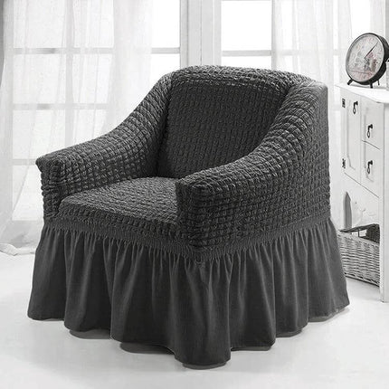 Four Seasons Universal Elastic Skirt Style Sofa Cover 90-140cm on a dark gray armchair showing textured stretch fabric and full skirt protecting the sofa