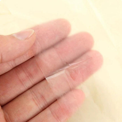 Disposable Toilet Seat Covers for Travel Hygiene Needs showing thin clear disposable cover material held on fingers
