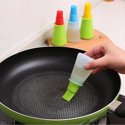 Kitchen Silicone Oil Brush Bottle 70ml being used to brush oil into a nonstick frying pan with green silicone brush head