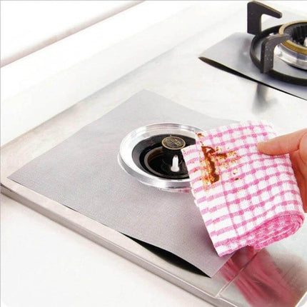 Gas Furnace Surface Stovetop Protective Pad 27x27cm shown on stainless gas stove catching spills and easy-to-wash fibre mat
