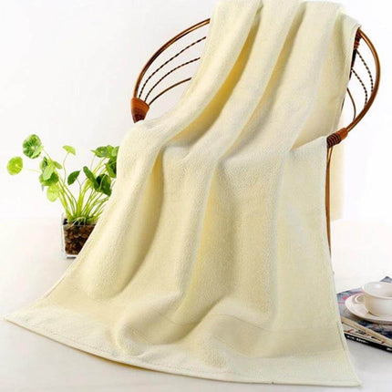 Bath Towel 70x140 cm For Everyday Home Use And Comfort draped on chair, 100% cotton high-absorbency soft towel, neutral cream color