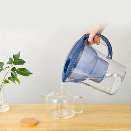 1.3L Portable Water Bottle With Activated Carbon Filter, Blue pouring filtered water into a glass teapot for on-the-go hydration