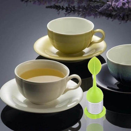 Food Grade Leaf Shaped Silicone Tea Infuser For Tea Time - compact green leaf silicone infuser with cup of loose-leaf tea