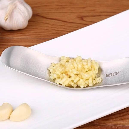 Garlic Press Stainless Steel For Everyday Garlic Crushing - 304 stainless ergonomic press showing freshly crushed garlic on spoon