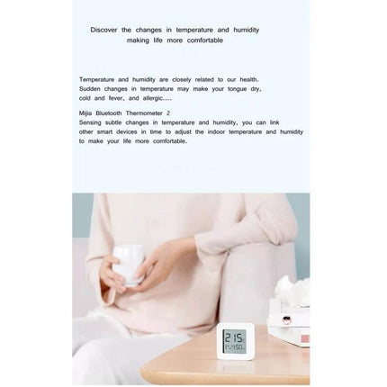 Xiaomi Mijia Bluetooth Temperature and Humidity Thermometer for Home Use on bedside table displaying temp and humidity in living room