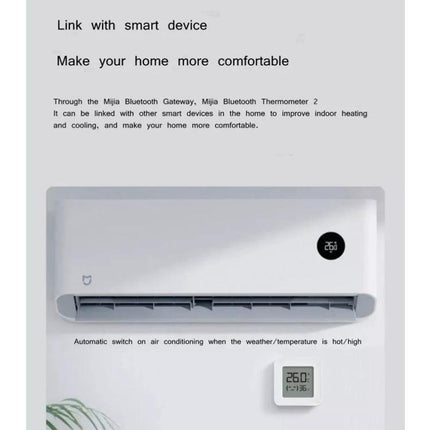 Xiaomi Mijia Bluetooth Temperature and Humidity Thermometer for Home Use wall-mounted near air conditioner showing temperature 26°C