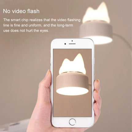 Cat-Shaped LED Lamp for Daily Desk and Night Use showing hands holding phone capturing soft, no-flash warm bedside lighting