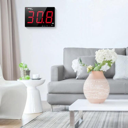SNDWAY Wall-Mounted Sound Level Meter with Large Display mounted in a living room showing large red numeric reading