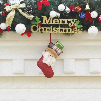 Hang Ornament Christmas Stockings Gift Bags For Decorating hanging red Santa stocking with gifts under garland and Merry Christmas sign
