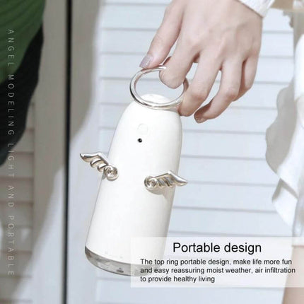 Mini Angel Atomizing Humidifier With Colorful Night Lights held by hand, compact portable 230mL tank with angel wings and night light
