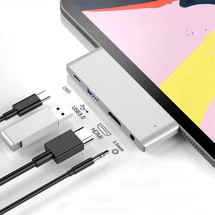 Versatile USB-C Hub for iPad Pro Connectivity Expansion attached to iPad Pro showing USB 3.0, HDMI, 3.5mm and PD charging ports