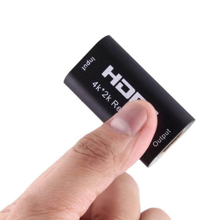 HDMI Signal Extender for Long-Distance Video Connections compact 4K HDMI signal regenerating adapter held between fingers