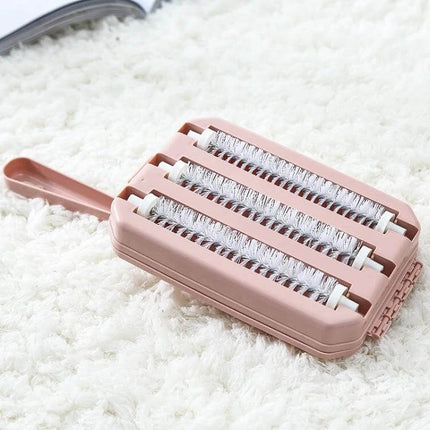 Handheld Carpet Brush Two-Row Design For Pet Hair And Debris on white rug, pink PP body with nylon bristles and ergonomic handle