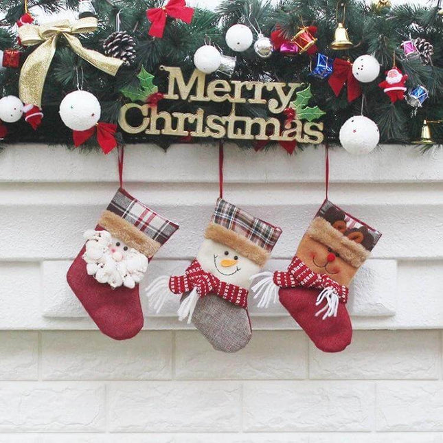 Hang Ornament Christmas Stockings Gift Bags For Decorating - three festive hanging Christmas stocking gift bags on mantel with Merry Christmas sign