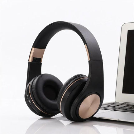 Candy Color Bluetooth Headphones With On Ear Controls For Daily Use shown in matte black with rose gold accents, laptop nearby