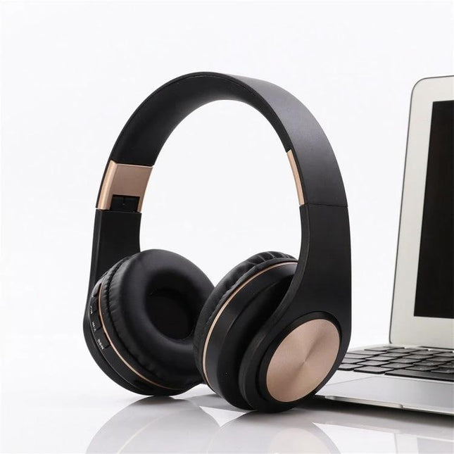 Candy Color Bluetooth Headphones With On Ear Controls For Daily Use shown in matte black with rose gold accents, laptop nearby