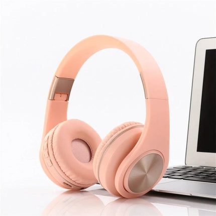 Candy Color Bluetooth Headphones With On Ear Controls For Daily Use shown in pink next to laptop, Bluetooth 4.2, on-ear controls for calls and music