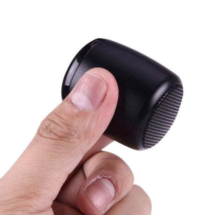 Compact Bluetooth Speaker For Music And Hands Free Calls - small black portable speaker held between fingers for travel