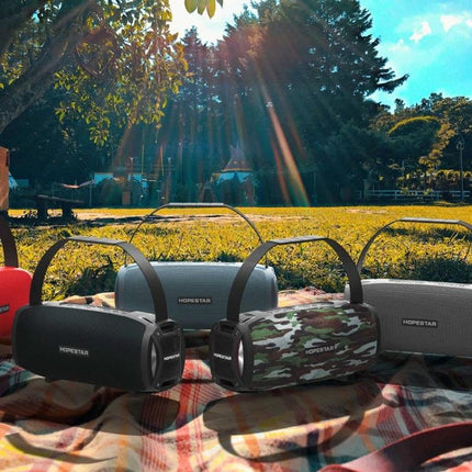 HOPESTAR Portable Bluetooth Speaker Weather Resistant shown on picnic blanket outdoors with multiple color options