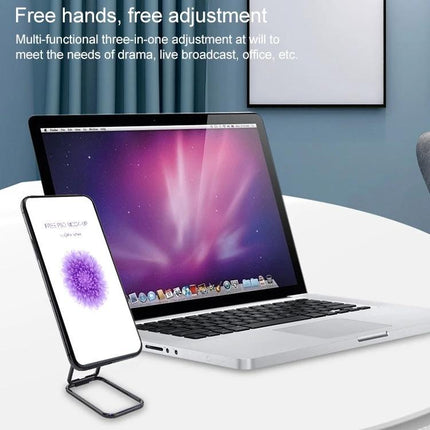 Cmzwt Adjustable Folding Magnetic Desk Phone Holder on desk next to laptop, folded stand holding smartphone for video calls and hands-free viewing
