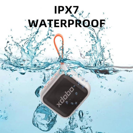 XDOBO Compact Bluetooth Speaker With Silicone Lanyard shown IPX7 waterproof in splashing water with orange lanyard attached
