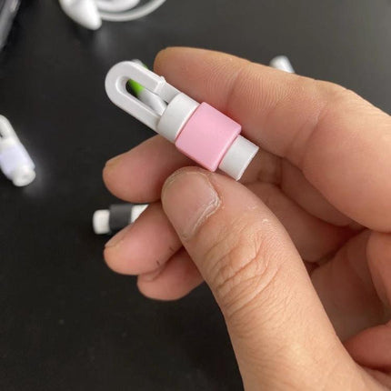 A Compact Organizer for Daily Earphone Cable Protection - pink and white cable clip held between fingers preventing tangles