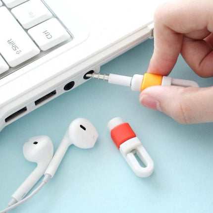 A Compact Organizer for Daily Earphone Cable Protection shown securing earphone jack and keeping white earbuds tangle-free near laptop