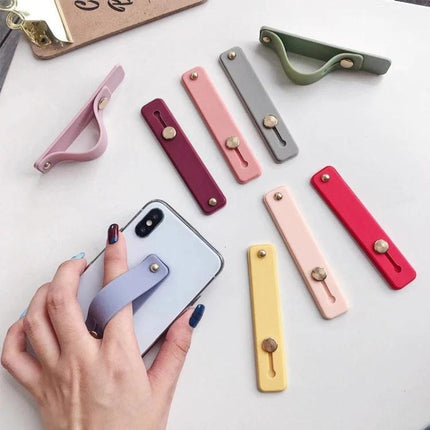 Versatile TPU Leather Phone Finger Strap Holder and Stand in pastel colors on white background showing adhesive strap attached to phone for grip and stand