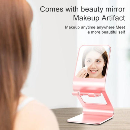 Metal Desktop Stand for Phones, Tablets and Makeup Mirror in pink metal with built-in mirror holding phone at angled viewing position