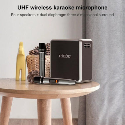 XDOBO Portable Bluetooth Speaker For Home And Picnics on table with wireless microphones, shoulder strap and picnic-ready portable design