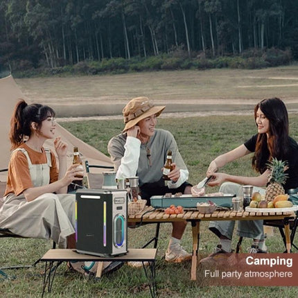 SINOBAND Portable Outdoor Speaker With Mood Light For Picnics beside friends at a picnic table creating a party vibe