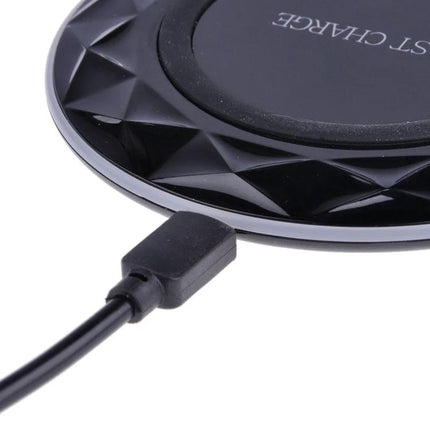 Essential wireless charging pad for everyday smartphone use at home - black round wireless charger on desk with USB cable