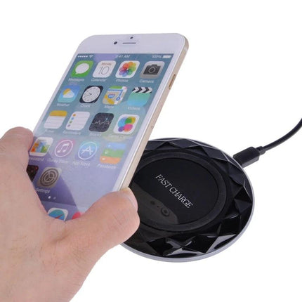 Essential wireless charging pad for everyday smartphone use at home - sleek fast-charge pad on a desk with smartphone being placed on it