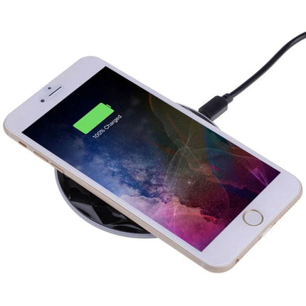 Essential wireless charging pad for everyday smartphone use at home - white phone charging on pad on desk