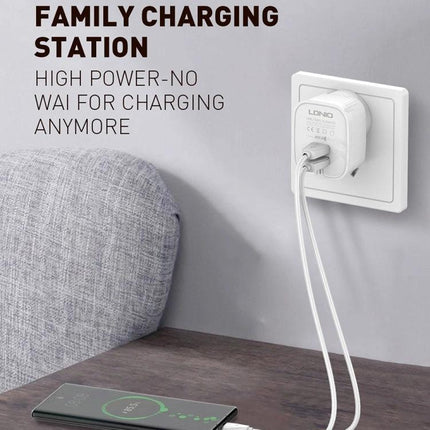 Keep Your Devices Charged During Daily Travels With LDNIO Charger plugged into wall powering two devices on a bedside table