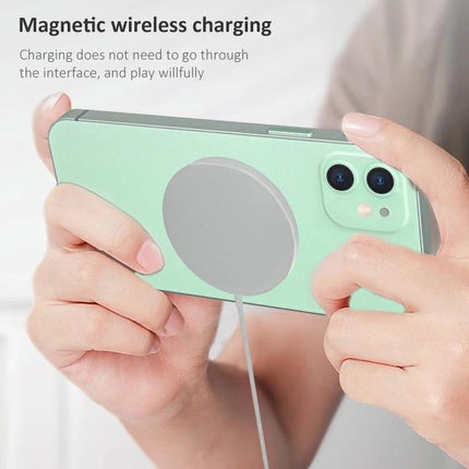 Compact Magnetic Charger for Home and Travel Use shown magnetically attached to the back of a phone for stable wireless charging at a desk or on the go