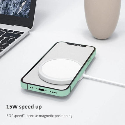 Compact Magnetic Charger for Home and Travel Use showing phone on white magnetic wireless pad on desk with laptop and cup, 15W fast charging
