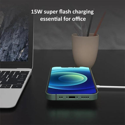 Compact Magnetic Charger for Home and Travel Use showing a phone magnetically aligned and charging on a desk beside a laptop
