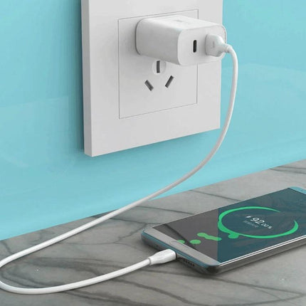 A Portable USB-C Charger for Your Everyday Device Needs charging smartphone on a countertop with compact wall adapter and cable