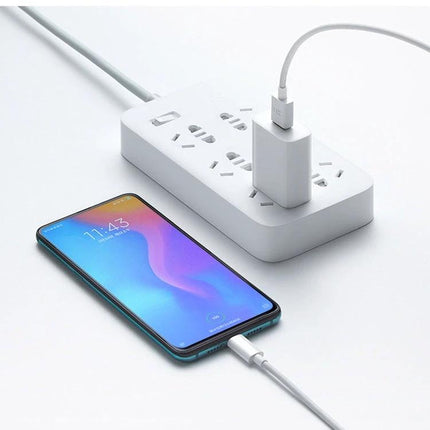 Xiaomi Wall Charger for Daily Use at Home and Travel in white plugged into power strip charging phone on desk