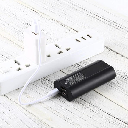 Tomo USB Battery Charger for 18650 Li-Ion Batteries black portable charger powering phone via USB on white wood surface