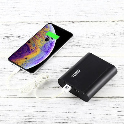 Tomo USB Battery Charger for 18650 Li-Ion Batteries powering phone via USB on wooden surface, black compact charger