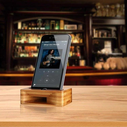 Natural Bamboo Universal Desktop Phone Stand for Smartphones holding a smartphone at desk for hands-free viewing