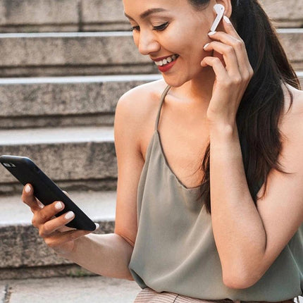 Wireless Earbuds For Commuting And Workouts With Magnetic Case showing woman using i11 TWS earbuds with phone