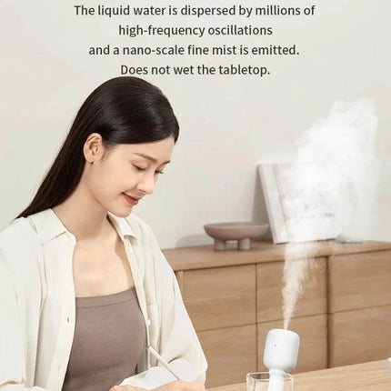 JisuLife Wireless High Mist Portable Humidifier White No Water Tank on desk producing nano-fine mist beside woman at workstation