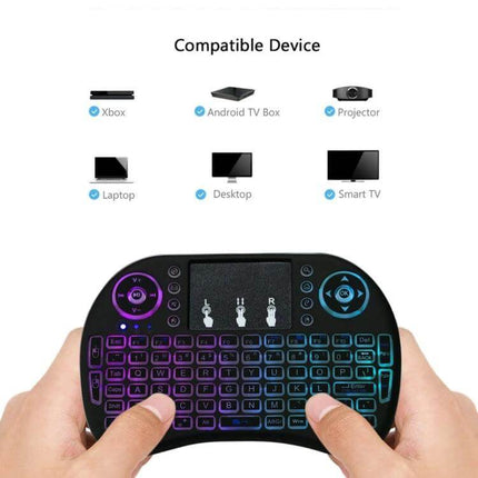 Wireless Mini QWERTY Keyboard with Touchpad for Smart Devices held in hands with glowing backlight showing compatible devices