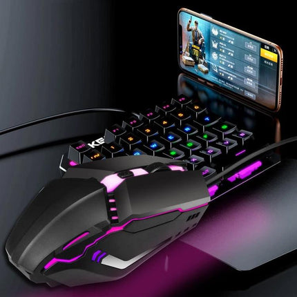 HXSJ Colorful Glowing Wired Gaming Mouse for Daily Tasks shown glowing pink beside compact RGB keyboard and smartphone for casual gaming and productivity