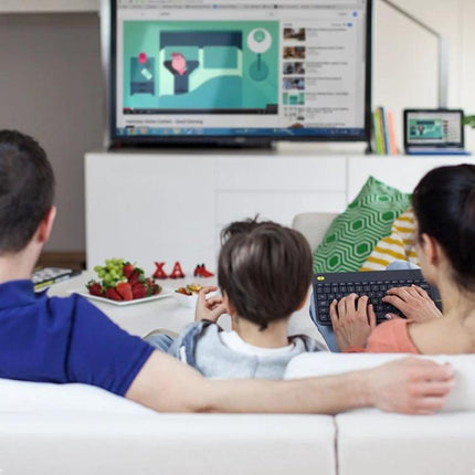 Logitech K400 Plus Wireless Keyboard for Living Room Navigation used by family on sofa to control TV playback with built-in touchpad and 10-meter wireless range