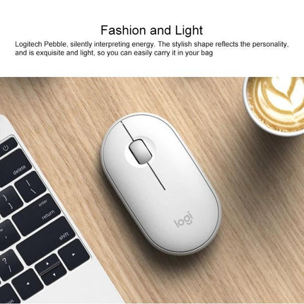 Logitech Pebble Portable Wireless Mouse with Silent Clicks on desk next to laptop and coffee cup